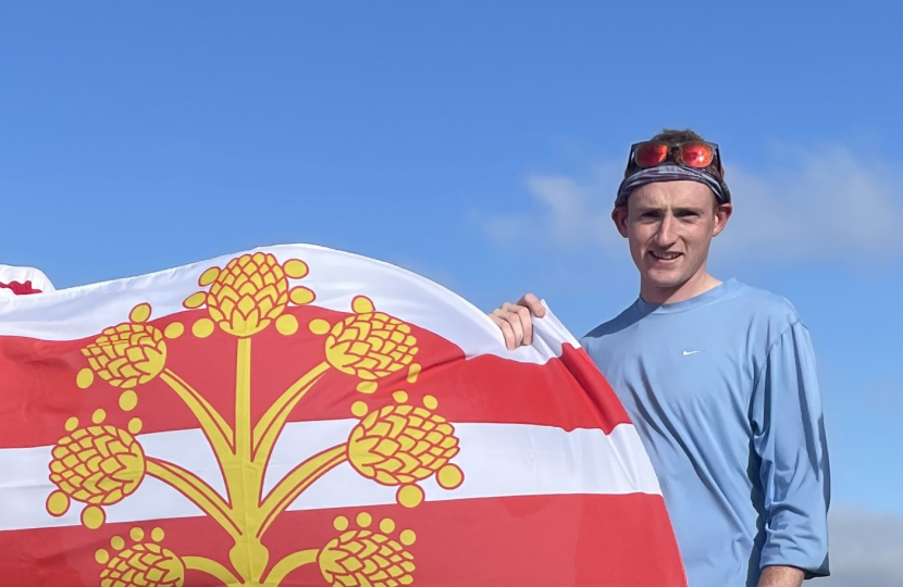 Matty Jackman stands atop Base Brown, proudly hoisting the County Flag of Westmorland, having completed all 214 Wainwright's (in 2021).